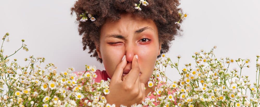 Uitgelichte afbeelding hooikoorts Vrouw heeft problemen met ademhalen tussen bloemen