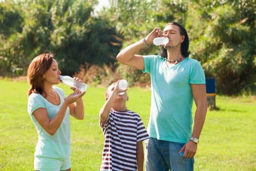 Ouders en kind die water drinken een van de tips om je metabolisme te versnellen.