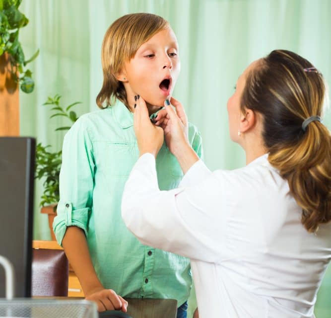 Dokter checkt de schildklier bij jongen