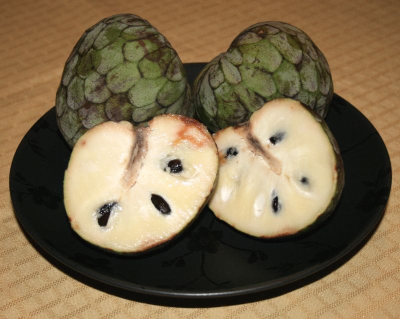 Cherimoya (zoetzaksuikerappel) op een zwart bord, wellnesstrends